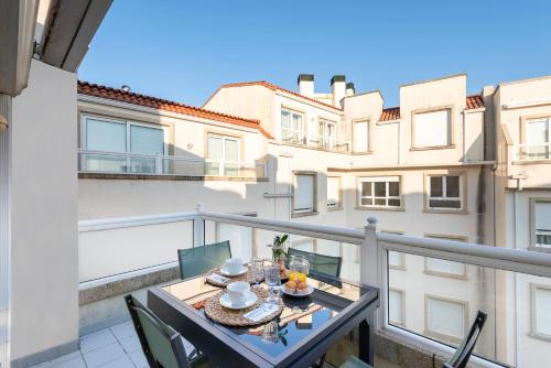 a balcony with a table with food on it at APARTAMENTO PLAYA SILGAR - VUT-50 m PLAYA CON 2 GARAJES Y 3 DORMITORIOS in Sanxenxo