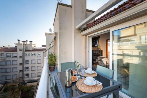 a balcony with a table and chairs and a view of a building at APARTAMENTO PLAYA SILGAR - VUT-50 m PLAYA CON 2 GARAJES Y 3 DORMITORIOS in Sanxenxo