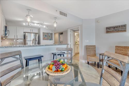 a dining room and kitchen with a glass table with a bowl of fruit at WINTER RATES! Oceanfront Work From Here Central Location! 1157 in Myrtle Beach