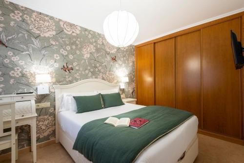 a bedroom with a bed with two books on it at APARTAMENTO PLAYA SILGAR - VUT-50 m PLAYA CON 2 GARAJES Y 3 DORMITORIOS in Sanxenxo