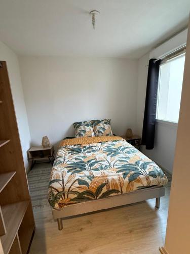 une chambre avec un lit dans une pièce avec une fenêtre dans l'établissement Appartement deux chambres paisible, à Vannes