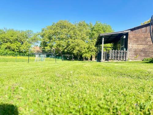 a field of grass with a building and a goal at Casa del Retiro in Nebersdorf