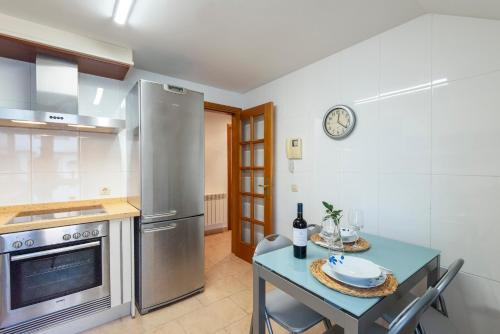 a kitchen with a blue table and a refrigerator at APARTAMENTO PLAYA SILGAR - VUT-50 m PLAYA CON 2 GARAJES Y 3 DORMITORIOS in Sanxenxo