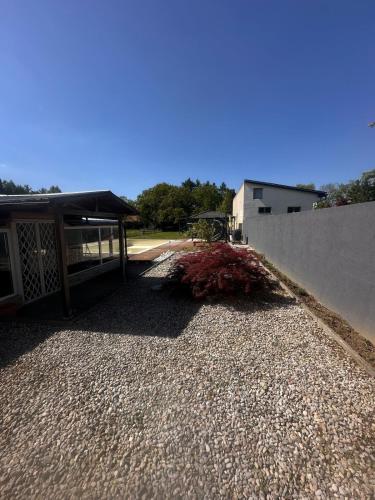 a gravel driveway next to a building with a fence at Casa del Retiro in Nebersdorf