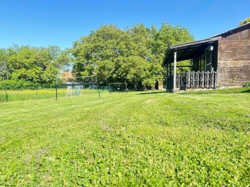 an empty field with a building and a soccer field at Casa del Retiro in Nebersdorf