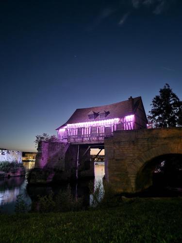 a building with purple lights on top of a bridge at A la belle Etoile de Paris à Honfleur in Cravent