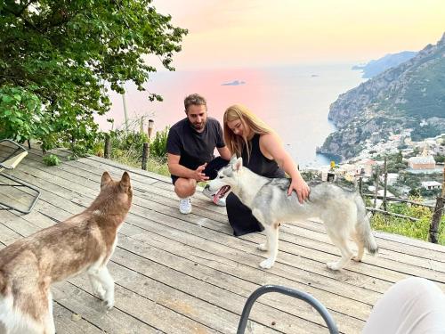 a man and a woman are petting two dogs at Colle dell'Ara in Positano