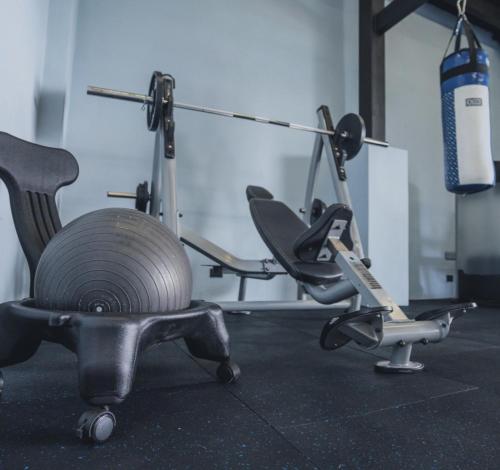 a gym with a chair and a fire extinguisher at La Parada House in Heredia