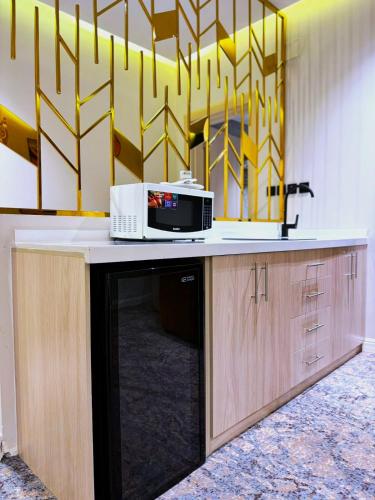 a kitchen counter with a microwave on top of it at Golden Sayf AlUla in AlUla