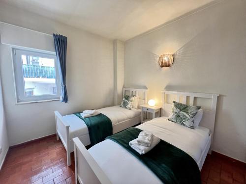 two beds in a small room with a window at Lagos Ocean Breeze 2 by Homing in Lagos