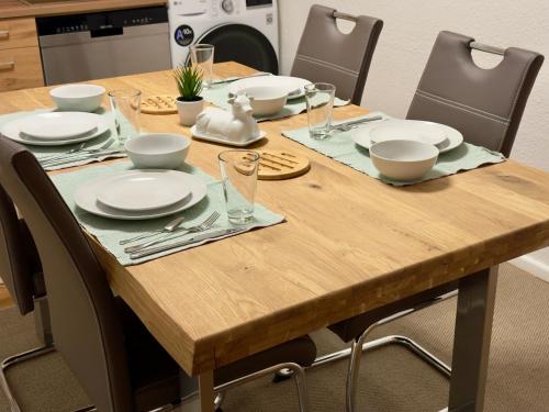 a wooden table with plates and utensils on it at Historisches Wohnen nahe Rathaus und Steintor in Malchin