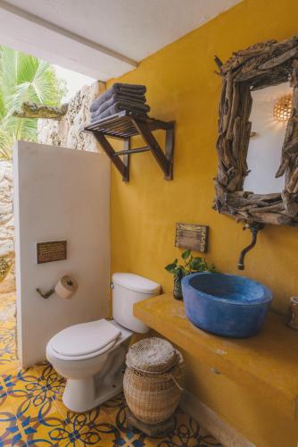 a bathroom with a toilet and a blue sink at Isla Fuerte Eco House in Isla Fuerte
