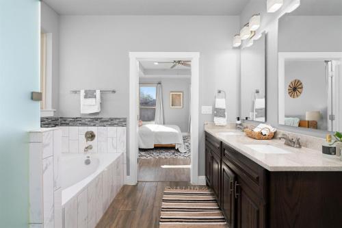 a bathroom with two sinks and a tub and a bedroom at LUXE Boho Chic5BR Woodbine Round Rock Kalahari in Round Rock