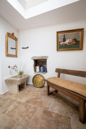 a living room with a bench and a fireplace at Mas de la Costete in Mons