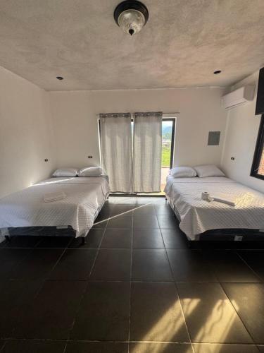 a bedroom with two beds and a large window at Casa condado in Esquipulas