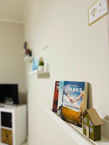 a shelf with a book and a house on it at Casa di Patty - Centro Storico in Asti