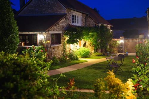 a stone house with a garden at night at A la belle Etoile de Paris à Honfleur in Cravent
