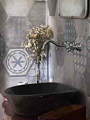a bathroom with a black tub with a vase of flowers at Il giardino di Chiara 1 Rifugio per anime stanche in Serrastretta