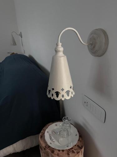 a lamp on a table next to a bed at Il giardino di Chiara 1 Rifugio per anime stanche in Serrastretta