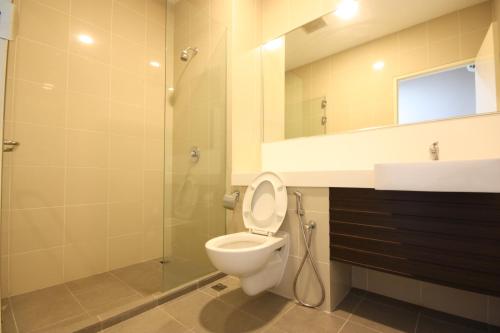 a bathroom with a toilet and a sink and a shower at 118 Residences by Travovo in George Town