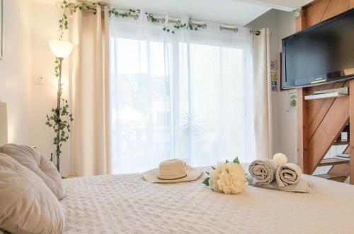 - une chambre avec un lit avec un chapeau et une fenêtre dans l'établissement Maisonnette très appréciée entre Mer et Nature Climatisée avec Cuisine Terrasse Parking, à Villeneuve-Loubet