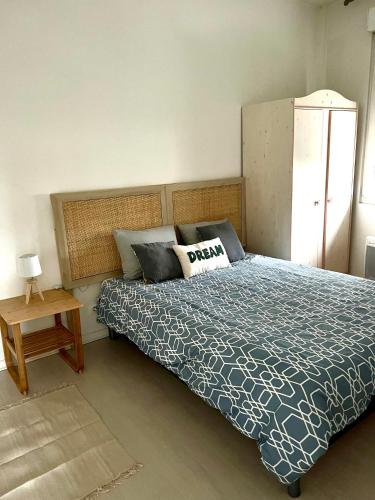 une chambre avec un lit avec une couette bleue et blanche dans l'établissement Good Loc, à Sens