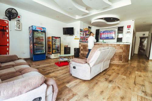 a man standing at a bar in a living room at Hotel California Air in Carepa