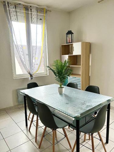 une table à manger avec des chaises et une plante en pot dans l'établissement Good Loc, à Sens