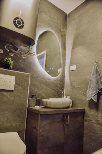 a bathroom with a sink and a mirror at Lux Grey in Đakovo