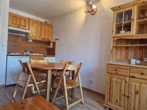 une cuisine avec une table et des chaises en bois dans l'établissement L'écureuil, à Risoul