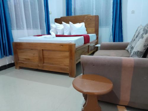 a bedroom with a bed and a couch and a chair at Valley Breeze Hotel in Dar es Salaam