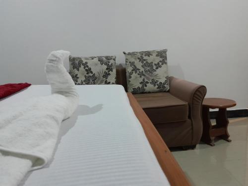 a bedroom with a bed and a couch and a chair at Valley Breeze Hotel in Dar es Salaam