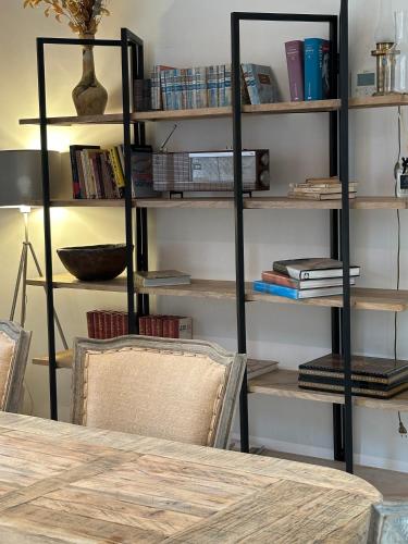 a room with a table and shelves with books at C'Anne Marie in Palafrugell
