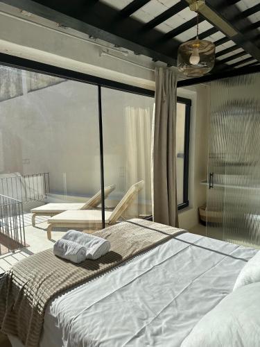 a bedroom with a large white bed with a window at C'Anne Marie in Palafrugell
