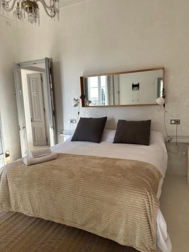 a bedroom with a large bed with a large mirror at C'Anne Marie in Palafrugell