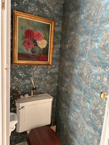 a bathroom with a painting of flowers on the wall at C'Anne Marie in Palafrugell