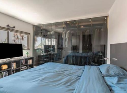 a bedroom with a bed and a flat screen tv at Penthouse Elysium in Mexico City