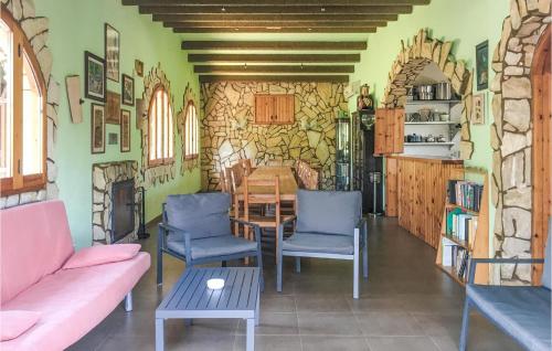 a living room with a table and chairs and a stone wall at Awesome Home In Ardenya With Wifi in Ardenya
