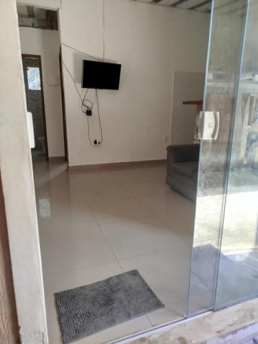 a living room with a tv on the wall at Recanto do Mauro in Mangaratiba