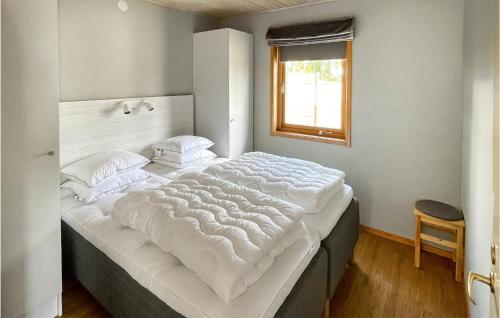 a large white bed in a room with a window at 2 Bedroom Lovely Home In Vaggeryd in Vaggeryd