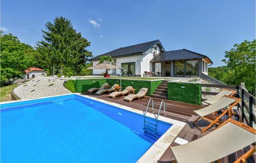 a swimming pool with chairs and a house at Pet Friendly Home In Vinica Breg in Gorušenjak