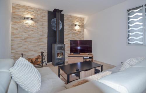 un salon avec un canapé blanc et une cheminée dans l'établissement Nice Home In La Capelle-Et-Masmolèn, à La Capelle-et-Masmolène