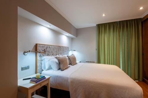 a bedroom with a large bed and a table with a lamp at APARTAMENTO TURISTICO A 140 M PLAYA CANELIÑAS- Portonovo- 2 Habitaciones 5 pax 202 in Portonovo