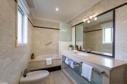 a bathroom with a sink and a toilet and a mirror at APARTAMENTO TURISTICO A 140 M PLAYA CANELIÑAS- Portonovo- 2 Habitaciones 5 pax 202 in Portonovo