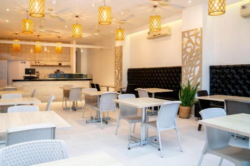 a restaurant with tables and chairs and a counter at Hotel Viña Del Mar in Santa Marta