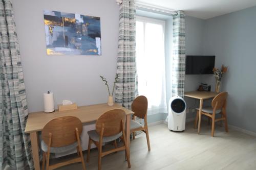 une salle à manger avec une table et des chaises en bois dans l'établissement Appartement élégant - Montmartre, à Paris