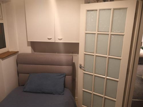 a small room with a bed and a cabinet at MossBank House Luton Airport in Luton