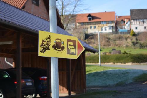 a yellow sign on a pole in front of a building at Waldecker Taverne in Bad Arolsen