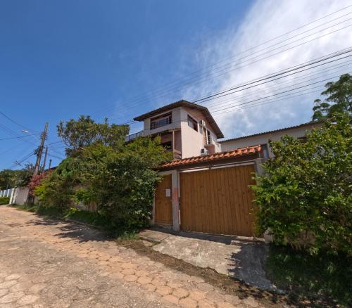 a house with a garage and a building at Santinho Hostel in Florianópolis