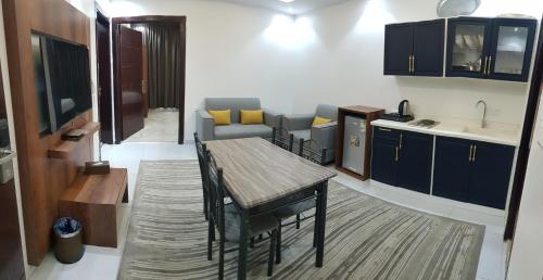 a kitchen with a table and a kitchen with a couch at درة الشرق للشقق المخدومة in Al Madinah